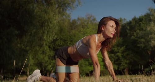 Woman Working Out with Band in Park