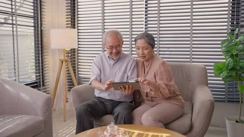 Senior Couple Using Tablet Together on Couch