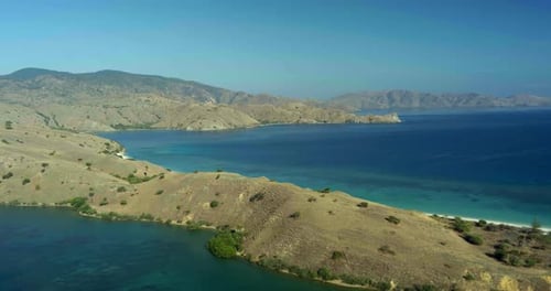 Drone aerial of green island hills and ocean coastline