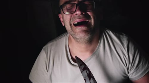 Crying Man With Bloody Knife in Dark Room