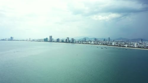 Drone, landscape and city at sea with a cloud, storm or rain in winter with town