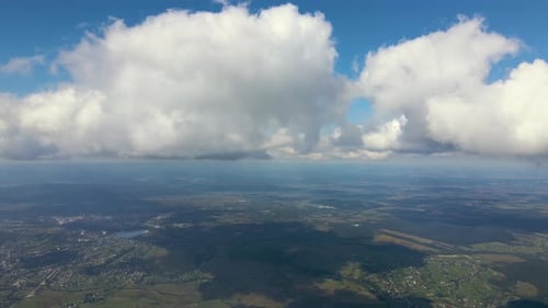 Vista aérea desde una gran altitud de una ciudad lejana cubierta de cúmulos hinchados que se formaban antes