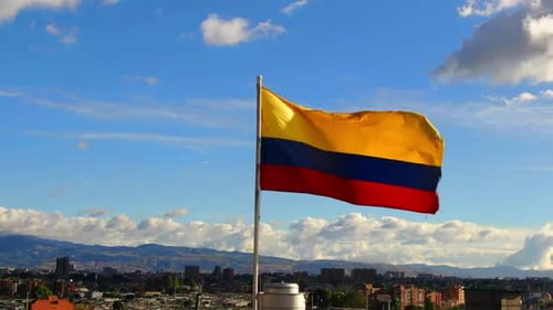 Colombian Flag Waving Above Bustling Cityscape