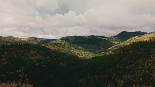 A Stunningly Lush Mountain Landscape Showcases Dramatic Clouds Soaring Above the Horizon