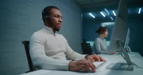 African American Hotline Operator Works on Computer Provides Online Assistance for Client