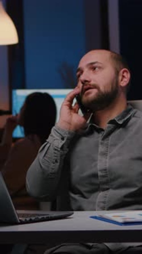 Adult Man Working at Desk Talking on Phone
