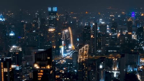 Aerial view of a vibrant city skyline at night with glowing buildings