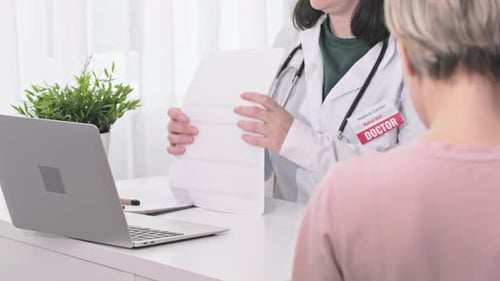 Female Doctor Therapist Filling Medical Forms in Laptop Patient Visit in Office