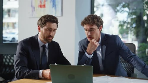 Focused Men Discuss Business in Modern Office