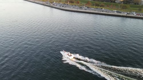 Speedboat Leaving Wake On Calm Waters Of Lake During Sunset. - aerial