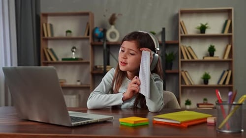 Young Child Girl Studying at Home Small Girl Sits at Desk and Attends School Class Online on Laptop