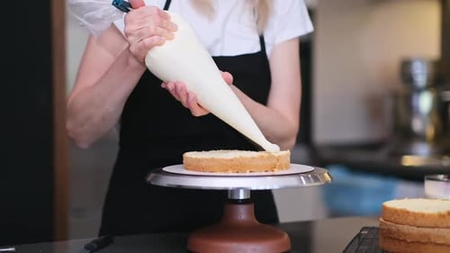 Woman Icing Cake in Modern Kitchen