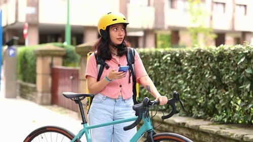 Woman with Bicycle Checking Phone on City Street