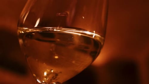 White wine being swirled around in wine glass; extreme close up