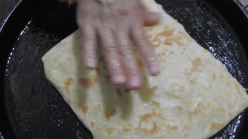 Spezielle marokkanische Pfannkuchen namens MSEMEN bei der Zubereitung in einer Eisenfritteuse