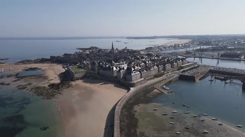 Môle des Noires and Saint-Malo old city, Brittany in France. Aerial forward. Sky for copy space
