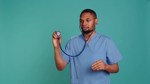 Doctor Holding Stethoscope in Blue Scrubs
