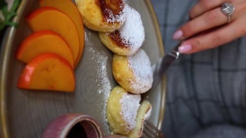 cottage cheese pancakes with jam and sour cream and English breakfast, eating in restaurant