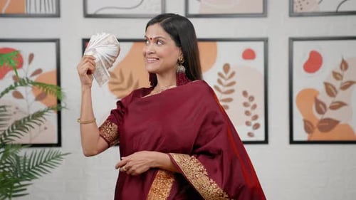 Woman Smiles and Fans Out Rupees
