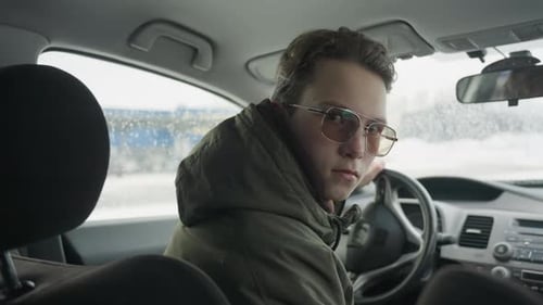 Young Adult in Car Looks Back