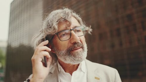 Clouse up, reifer Geschäftsmann in grauer Jacke benutzt Handy