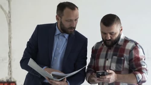 Businessman, Real Estate Agent with Client Checking Documents with Smartphone at New