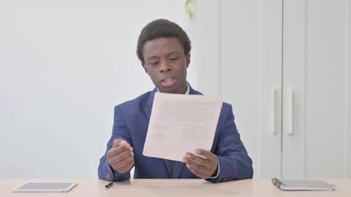 Young Adult Reviewing Document at Desk