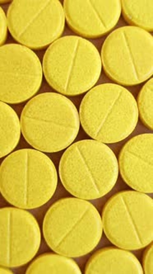 Medical Yellow Pills on Rotating Table Close Up Vertical Video