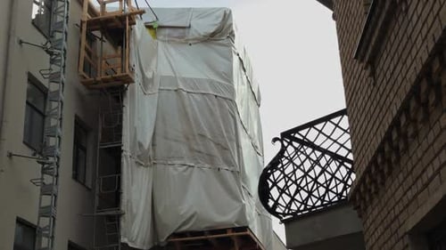 Un edificio que se encuentra actualmente en construcción con andamios y cubiertas de lona para