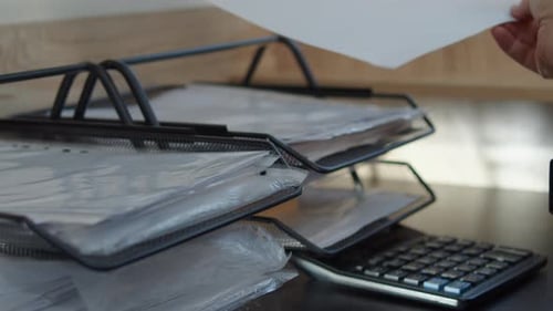 Hand Placing Document Into Office Paper Tray