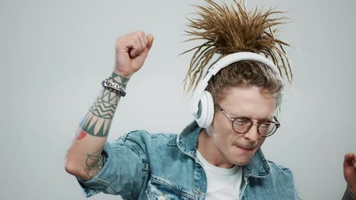 Smiling man dancing to music in headphones enjoying entertainment at studio