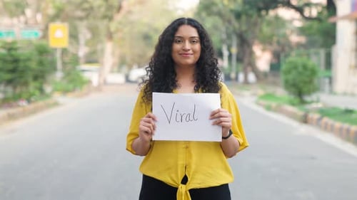 Curly Hair Indian Girl Standing with Viral Poster
