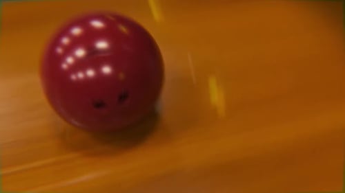 Bowling ball rolling down lane for a strike in dynamic motion footage