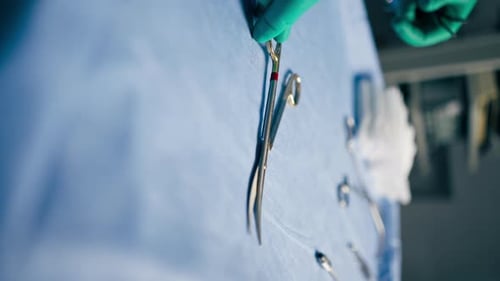 Vertical Video Closeup in Operating Room the Lower Surgeon in Green Gloves Lays Out Instruments on