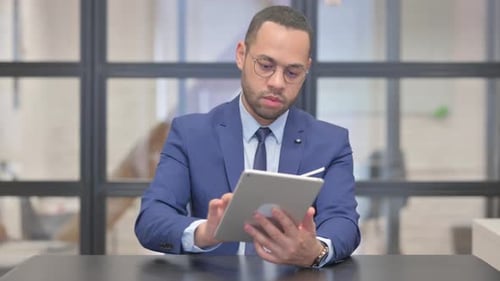Mixed Race Businessman Using Digital Tablet in Office