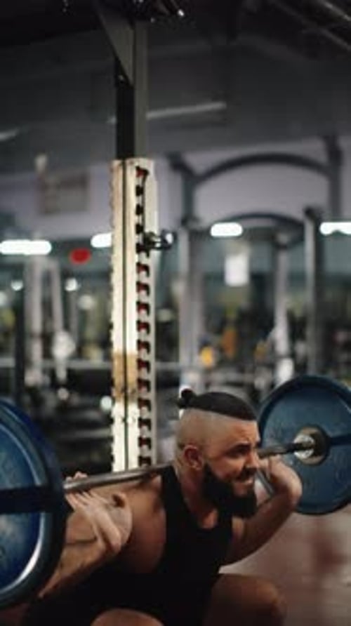 Bearded Man Doing Squats with Barbell