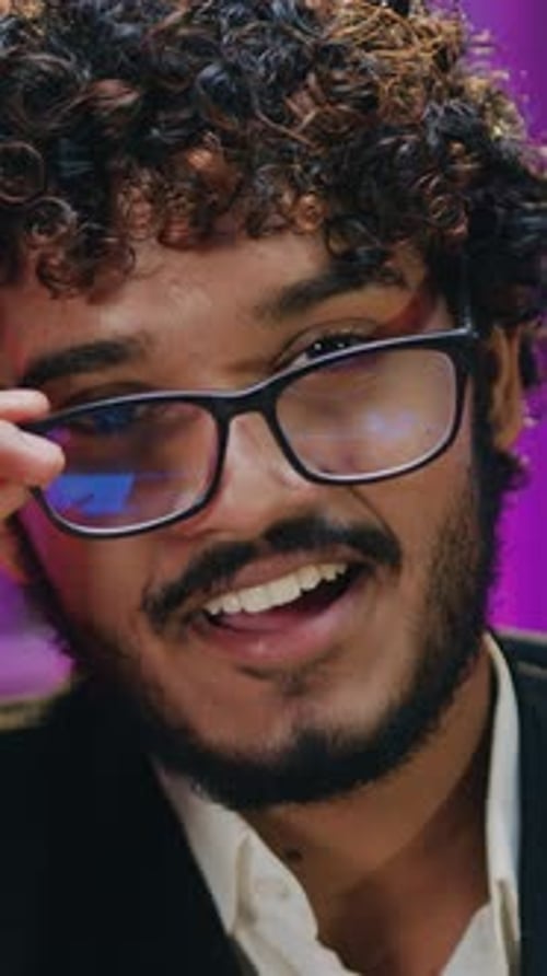 Close-up of smiling man removing glasses