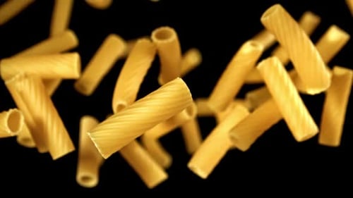 Rigatoni pasta falling in slow motion on black