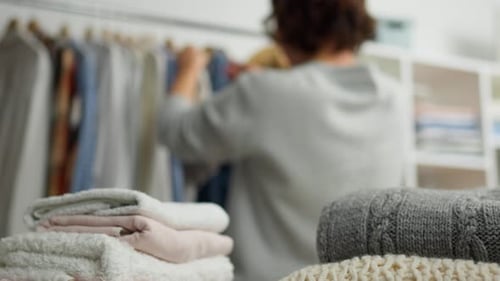 Person Sorting Clothes in Home Setting