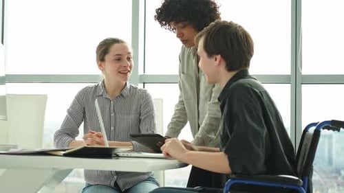 Young Adults Work Together at an Office Table