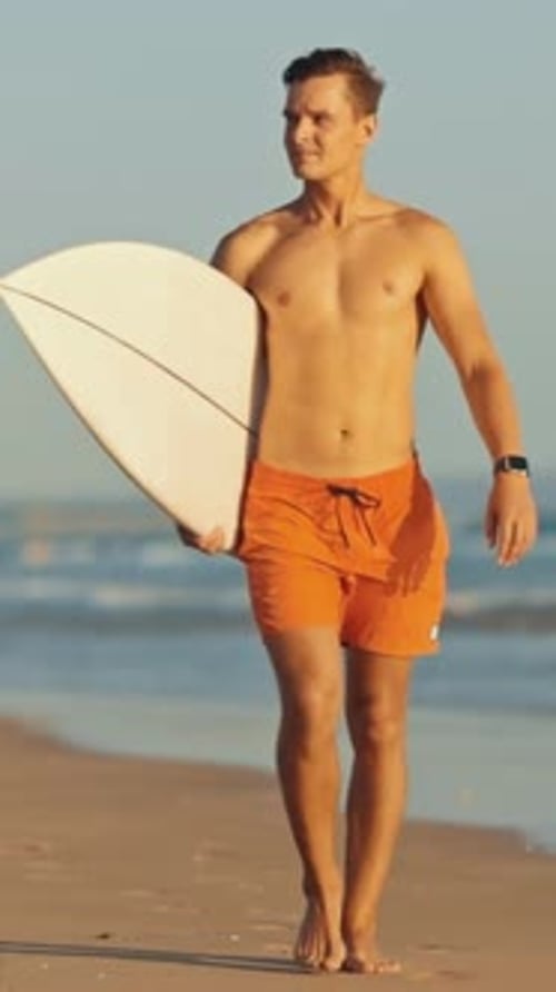 Surfer Walking on the Beach with Surfboard