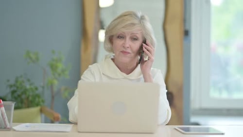 Woman Talking on Phone While Working at Computer