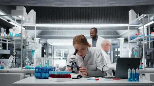 Clinical Microbiologist Using Compound Microscope for Detailed Cellular Analysis