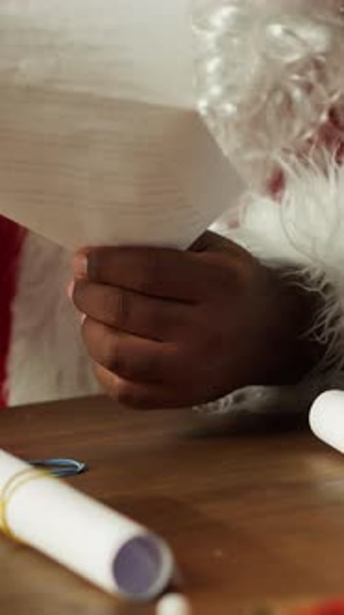 Santa Suit Figure Opens Rolled Up Letters