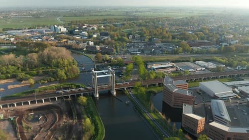 Tren ligero NS Sprinter que pasa por el puente del tren (Spoorbrug) en Gouda, Países Bajos. Seguimiento aéreo sh