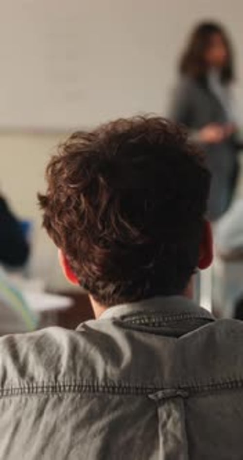 College, student and listening to lesson in classroom, education and teacher with assignment advice