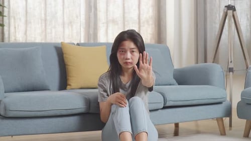 Injured Woman Makes Stop Gesture Indoors
