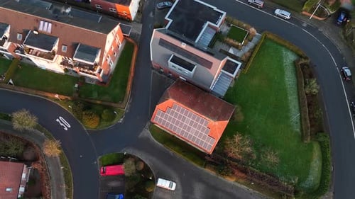 Townhouses and homes with solar panels on roof during golden sunset. Aerial top down flyover. Americ