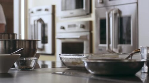 Pan of Pots, Pans, and Ingredients on a Kitchen Counter in Interior