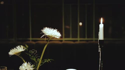 Close up of Candle and Flowers at Dinner
